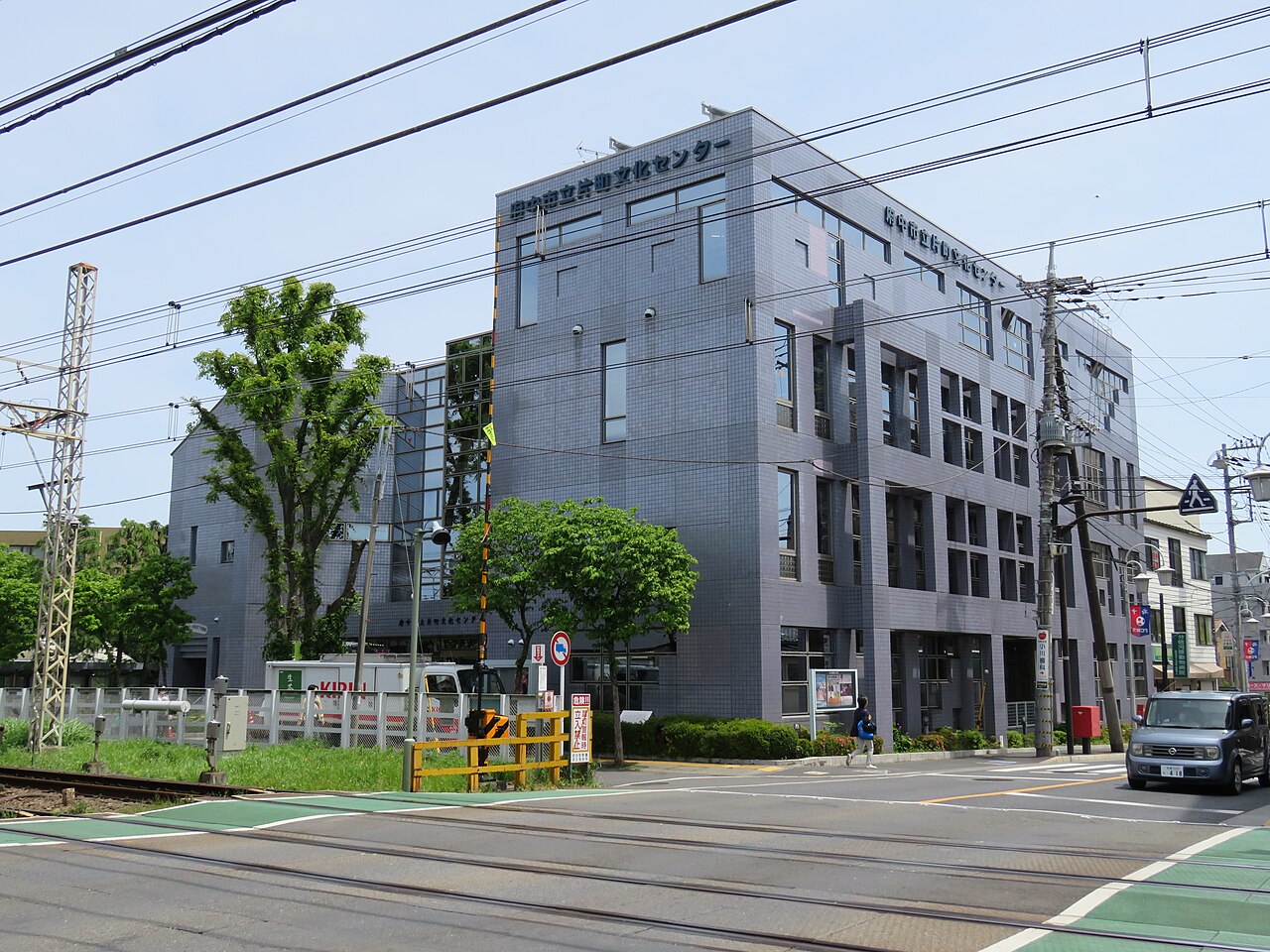 道路と踏切側から見た府中市立片町文化センターの外観