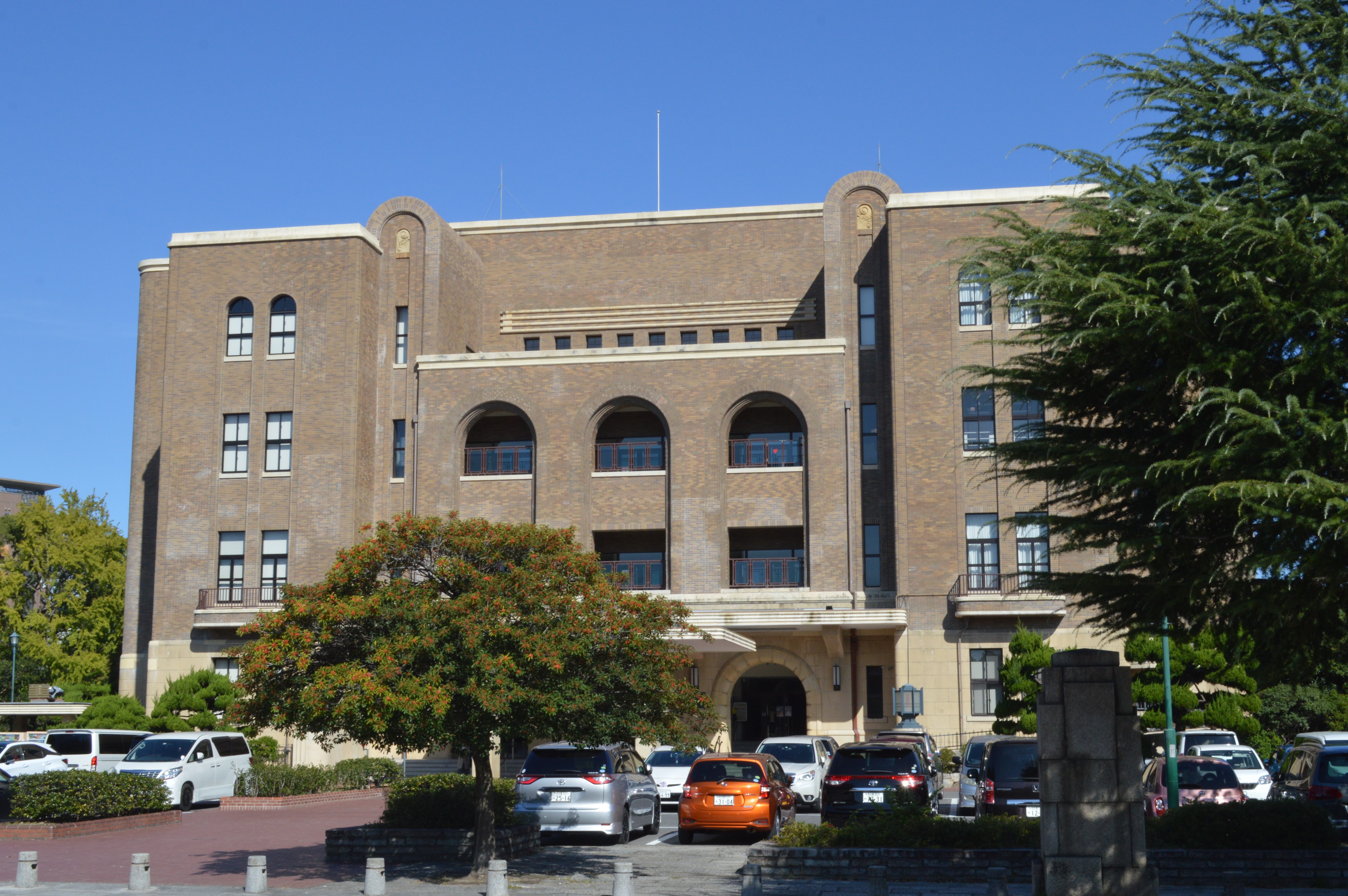 樹木越しに見る名古屋市公会堂の外観