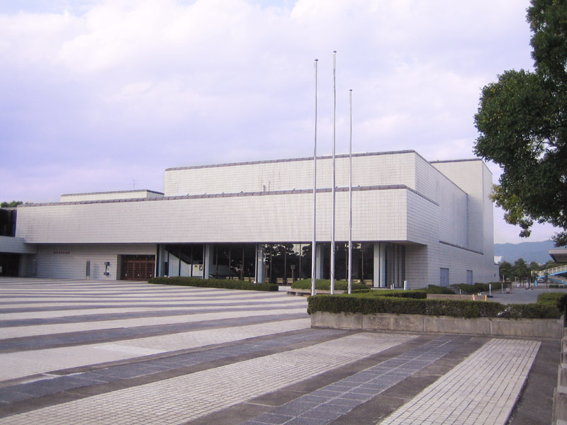 旗竿と正面入口が見える豊川市文化会館の外観