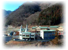 山間の敷地に立つ施設の遠景外観